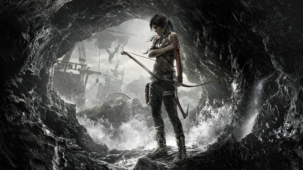 難破船が沈む洞窟の中で、泥にまみれた弓を構えるララ・クロフト。Tomb Raider のキービジュアル